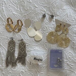 Assorts of stylish earrings and belly rings .